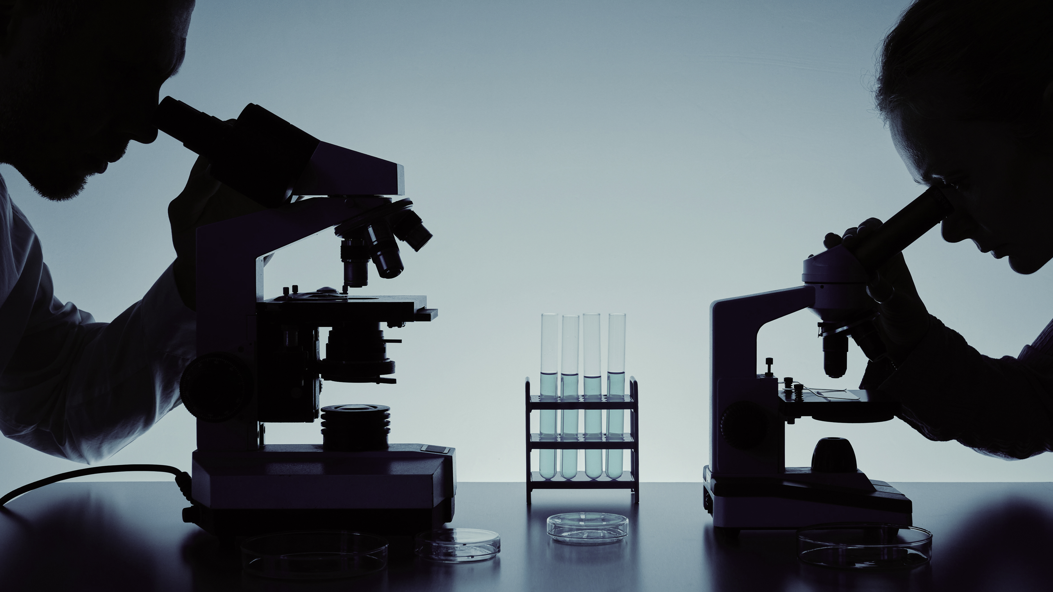 A laboratory scientist examining a sample through a microscope