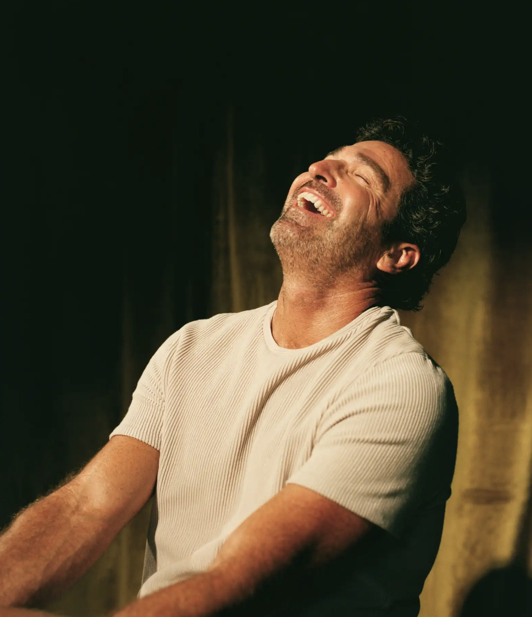 A person laughing in warm light